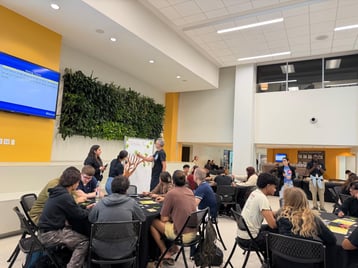 Students at table during a lecture style event.